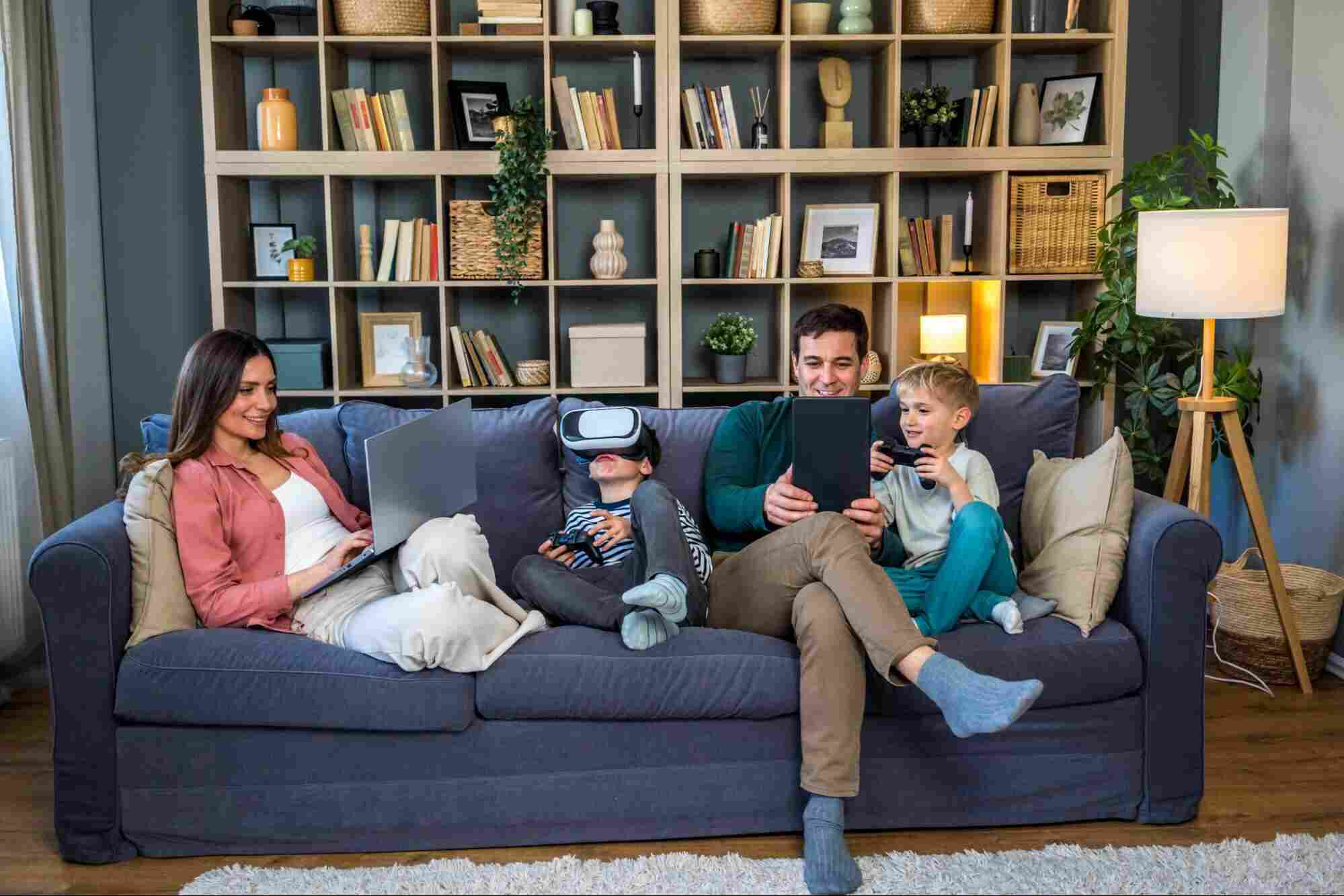 Family using multiple connected devices at home, highlighting the benefits of fast, reliable fiber internet for work, learning, and entertainment.