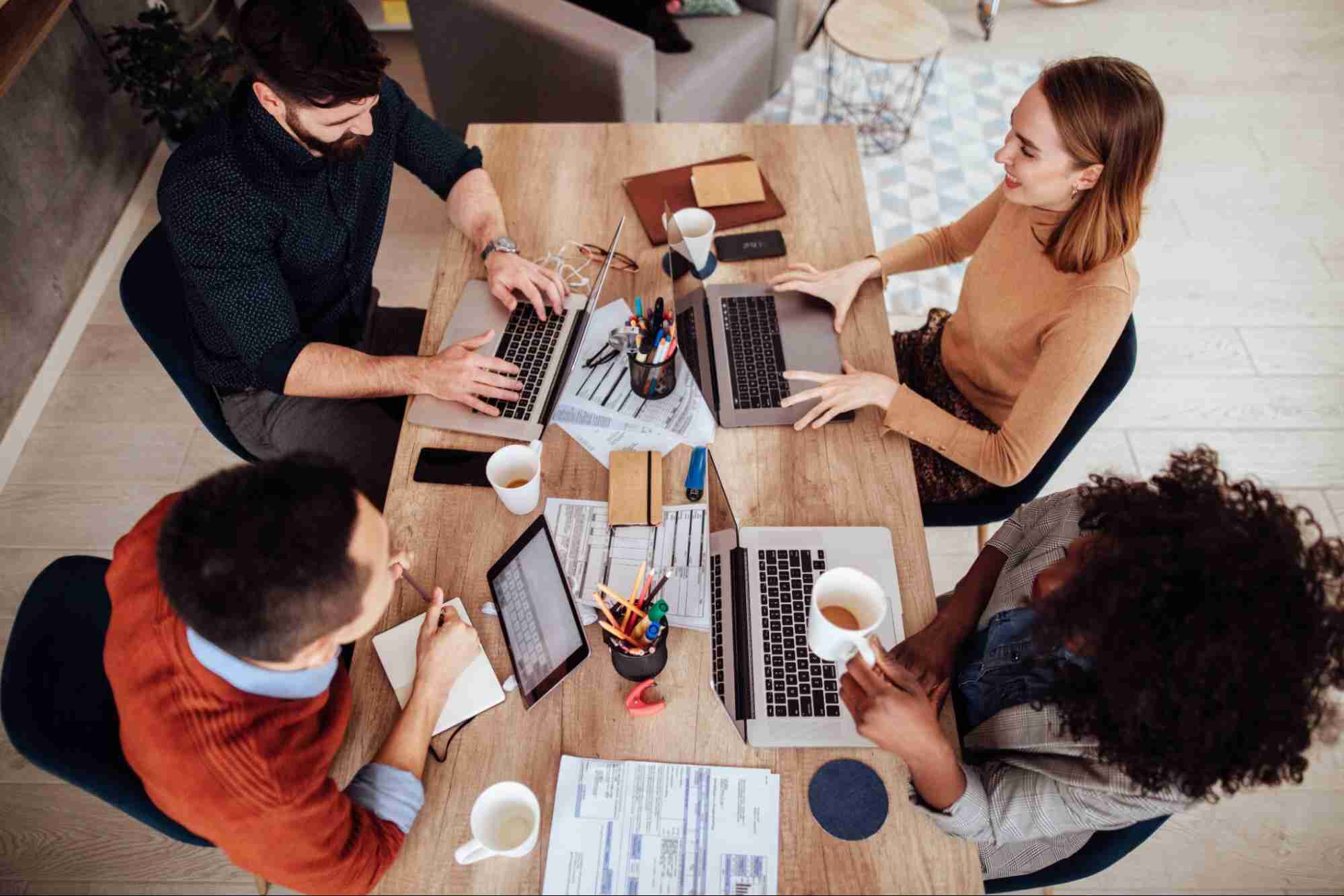 Business professionals collaborating around a table, showing how fiber helps communities stay competitive through reliable connectivity and innovation.
