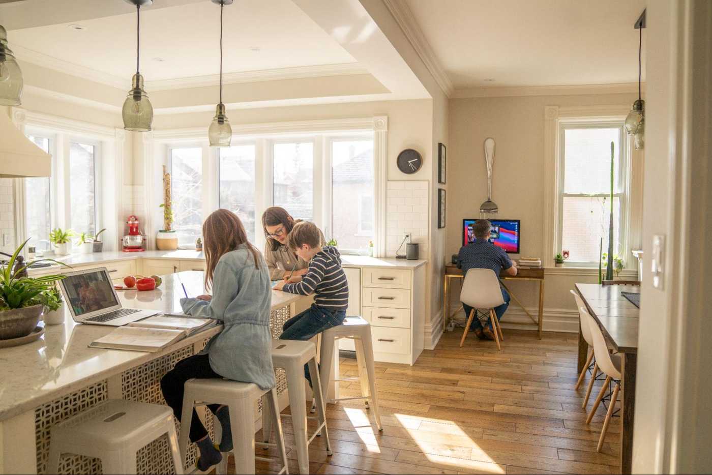 Family using laptops and computers at home, showing how fiber infrastructure brings reliable connectivity to Three Hills households for work, learning, and everyday internet use.