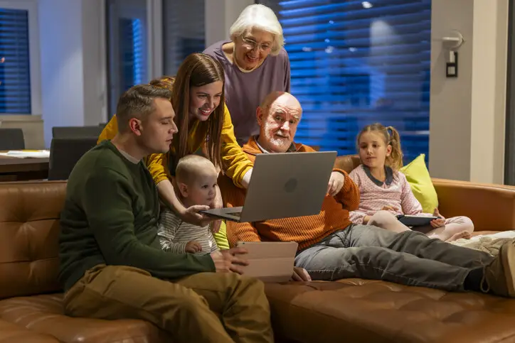 Family using multiple connected devices at home while comparing internet options, illustrating choosing the right internet in Whitecourt for reliable home connectivity.