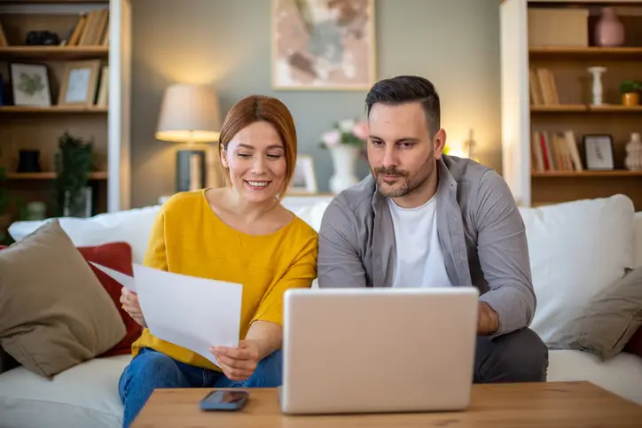 Couple comparing internet plans and reviewing monthly costs online to choose the best home internet service in Whitecourt.
